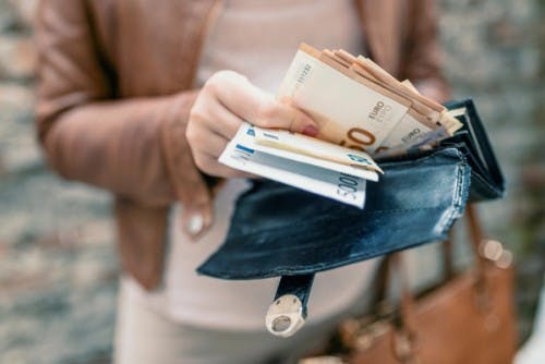 Person drar ut kontanter fra en lommebok